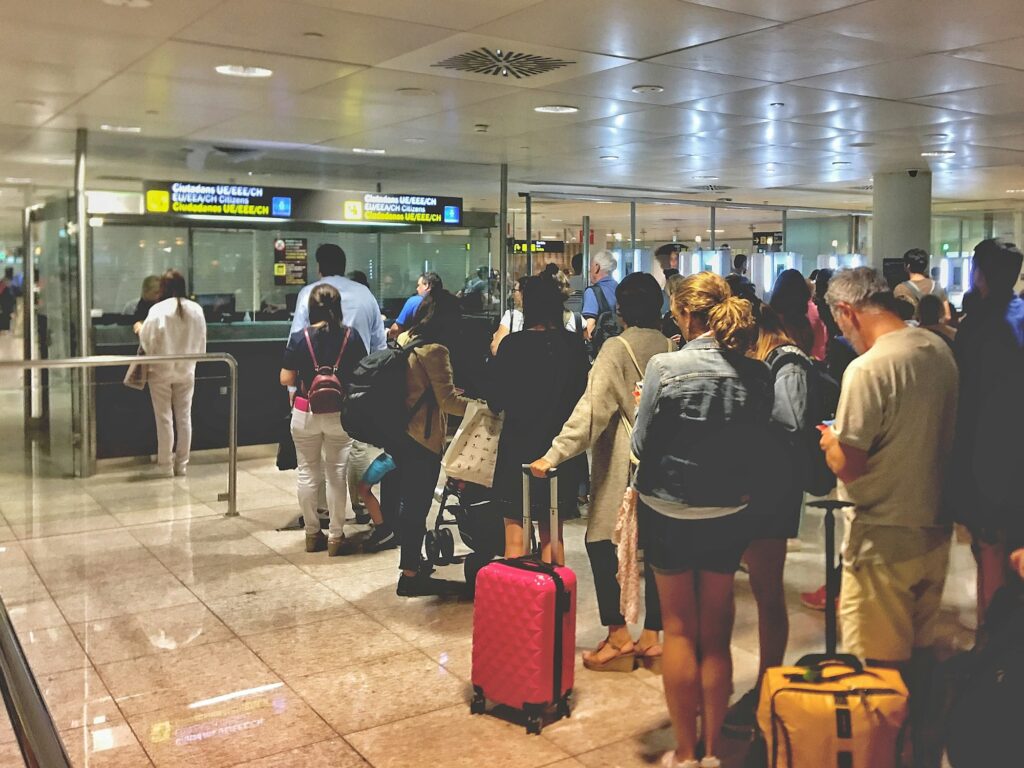 Travelers stand in line at customs and immigration at the airport.